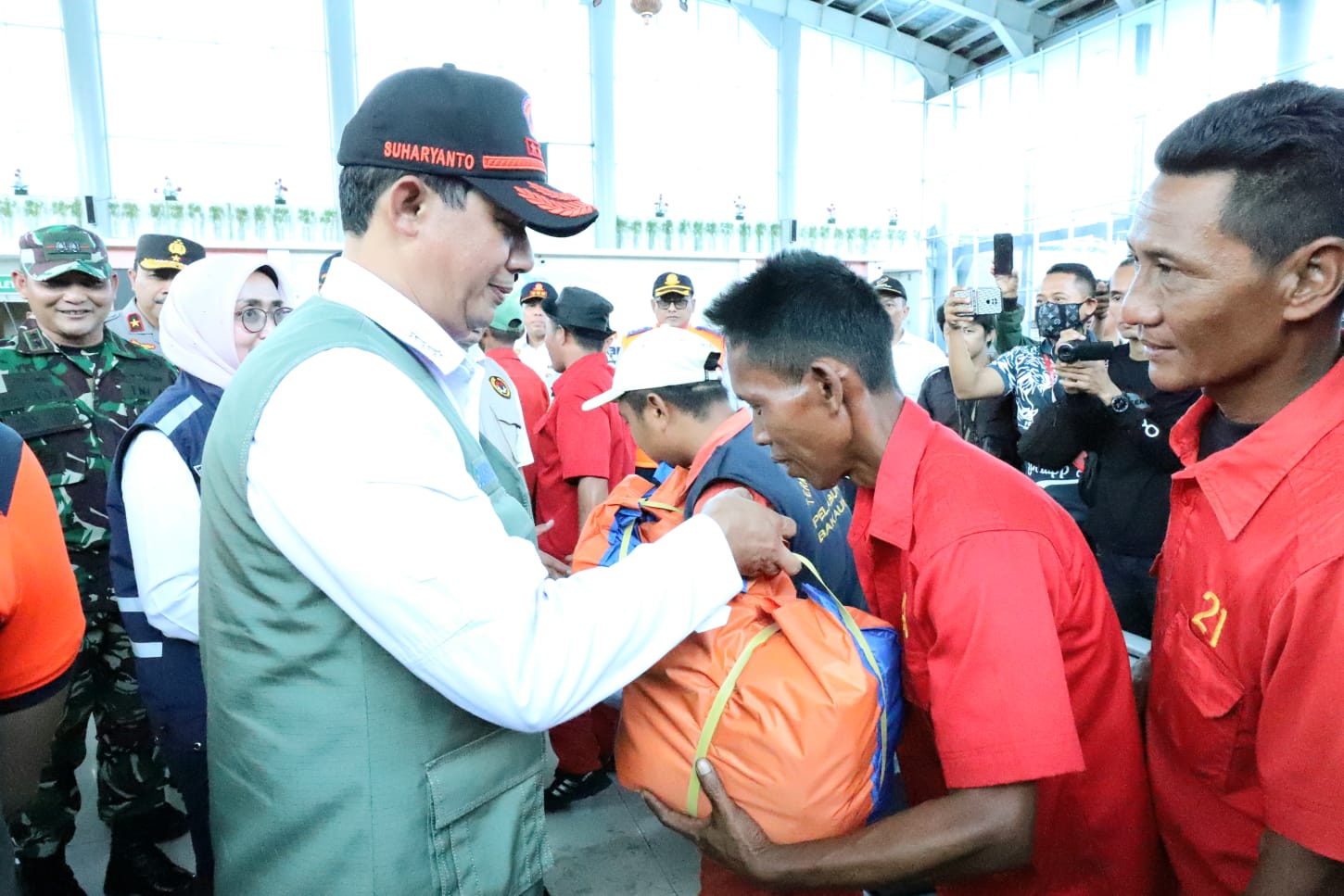 Kepala BNPB Letjen TNI Suharyanto dan Menko PMK Muhadjir Effendy memberikan bingkisan kepada para porter di Pelabuhan Bakauheni, Lampung Selatan, Provinsi Lampung, pada Selasa (25/4).